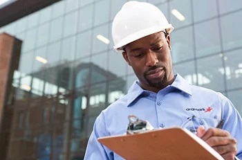 Aramark Employee in white hardhat and clipboard.
